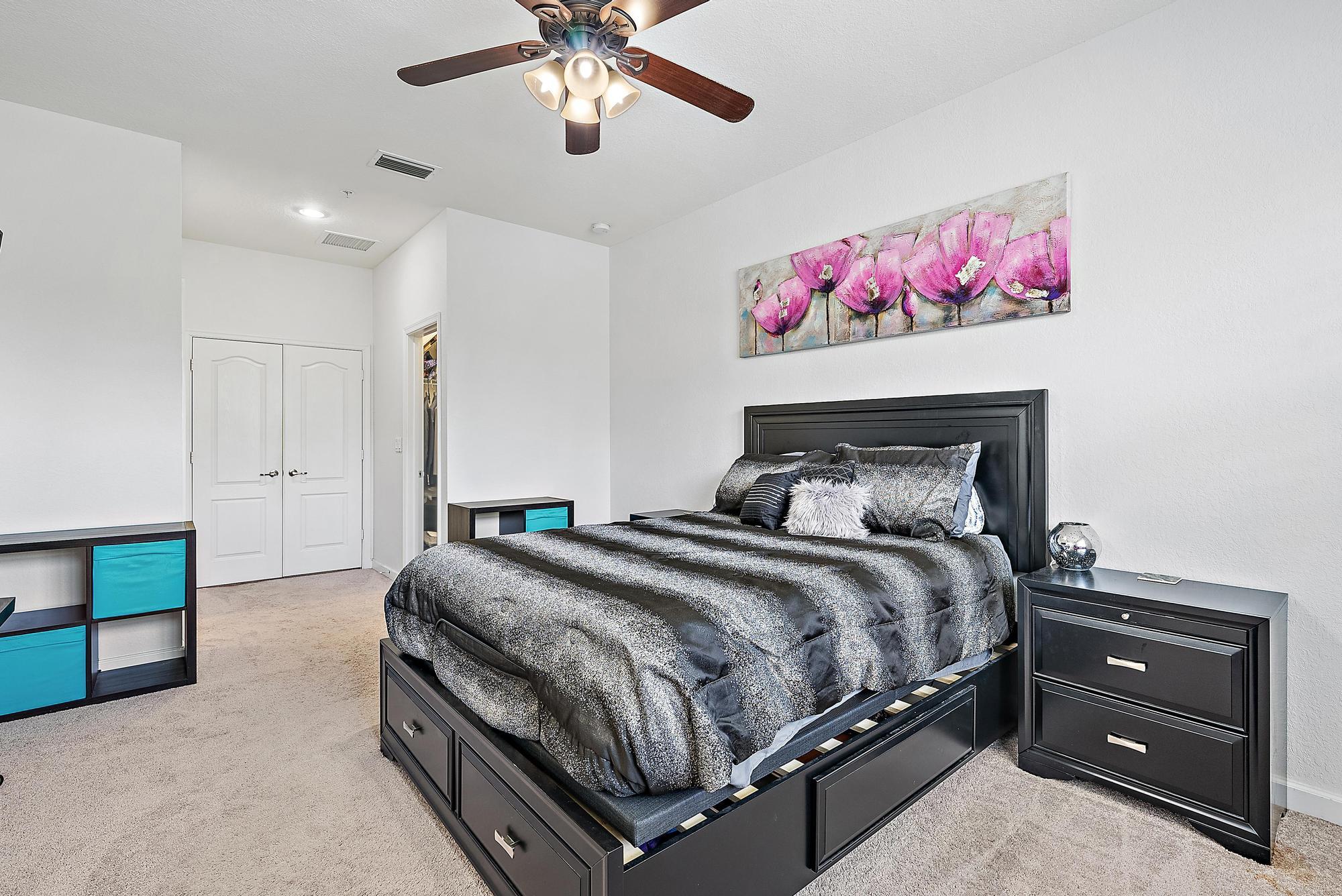 9677 Southwest Purple Martin Way Stuart, FL 34997 - Photo 12 of 29 a bedroom with a bed and a chandelier