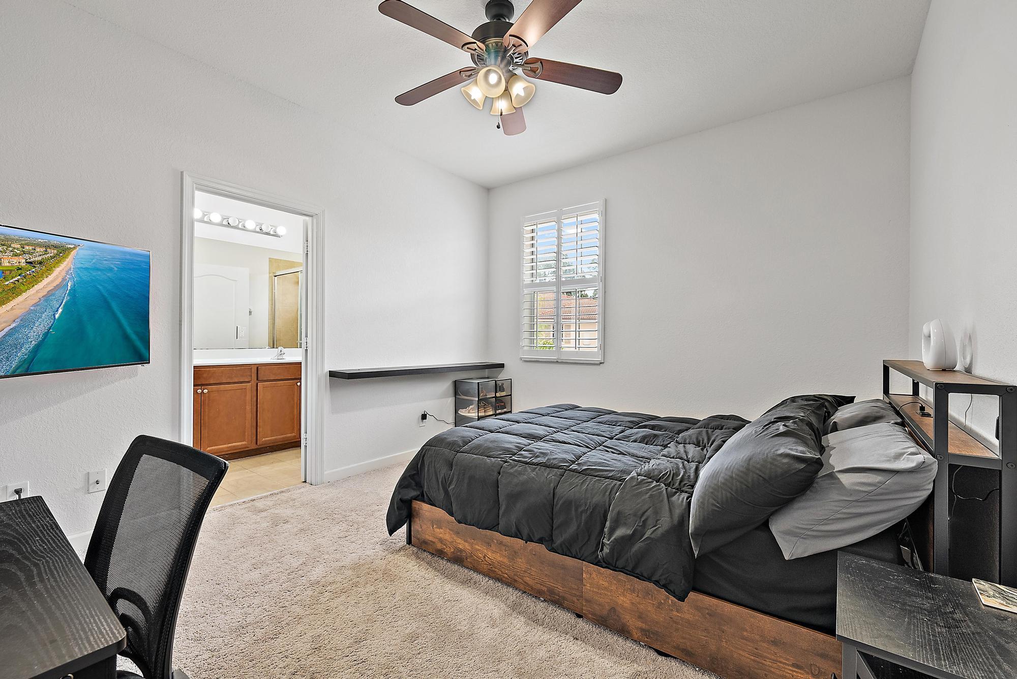 9677 Southwest Purple Martin Way Stuart, FL 34997 - Photo 16 of 29 a bedroom with a bed and window