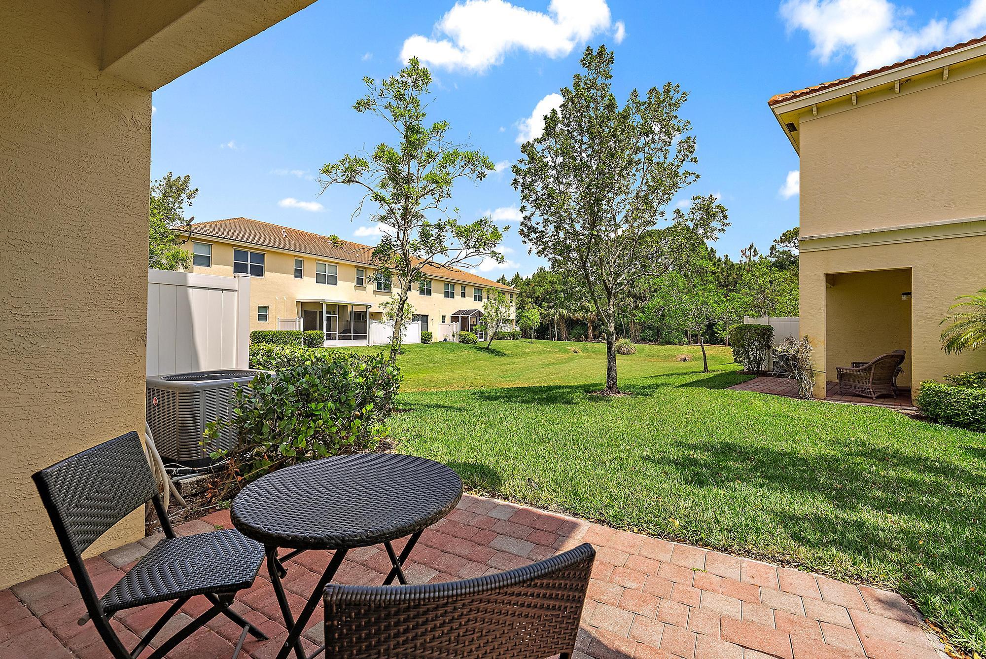9677 Southwest Purple Martin Way Stuart, FL 34997 - Photo 20 of 29 a view of a patio with table and chairs and potted plants