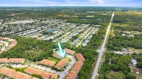an aerial view of residential houses with outdoor space and trees