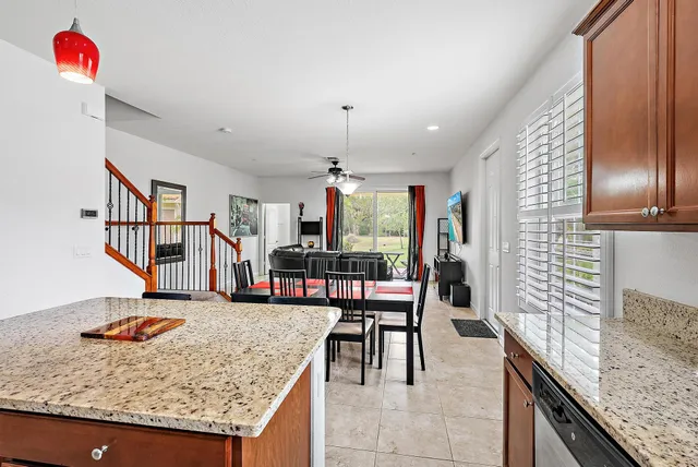 a kitchen with stainless steel appliances kitchen island granite countertop a table chairs in it and wooden floors