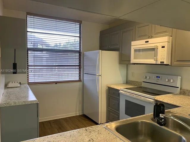 a kitchen with a refrigerator and a sink