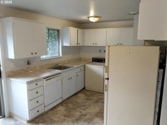 a kitchen with a sink cabinets and appliances