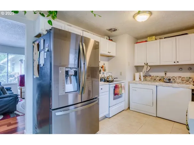a kitchen with stainless steel appliances a refrigerator sink and cabinets