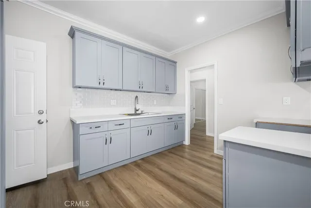 a kitchen with a sink cabinets and wooden floor