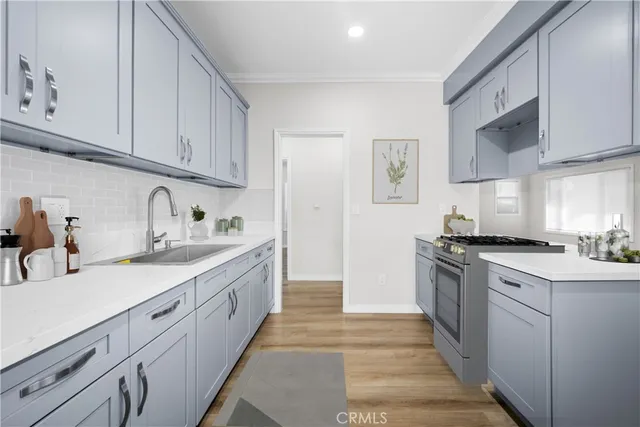 a kitchen with stainless steel appliances granite countertop a sink and dishwasher a stove top oven with white cabinets