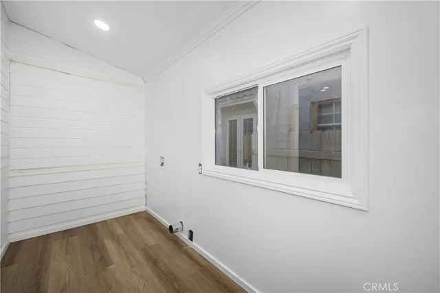 a view of a small space with wooden floor and a window