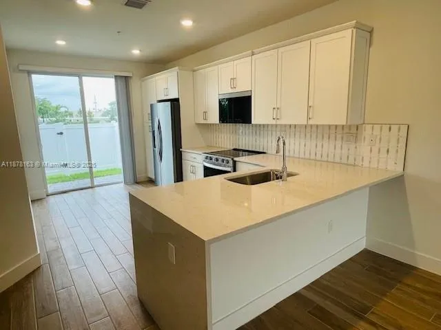 a kitchen with stainless steel appliances a microwave a sink and cabinets