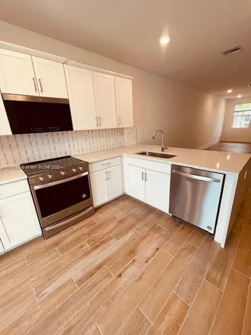 a kitchen with stainless steel appliances granite countertop a sink stove and microwave