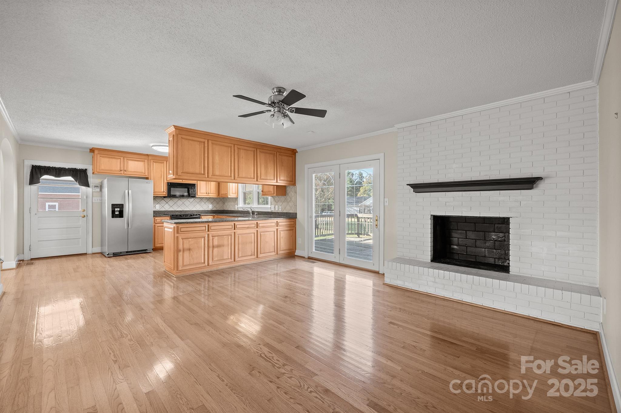 484 Stutts Road Mooresville, NC 28117 - Photo 7 of 28 a view of a kitchen with stainless steel appliances wooden floor and a fireplace