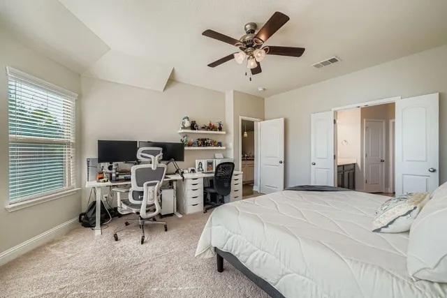 a bedroom with a bed a chair and a chandelier