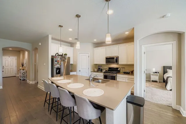 a view of a dining room and livingroom with furniture wooden floor a chandelier