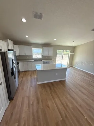 a view of kitchen with wooden floor and electronic appliances