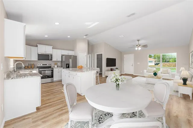 a kitchen with a white wooden cabinets and a window