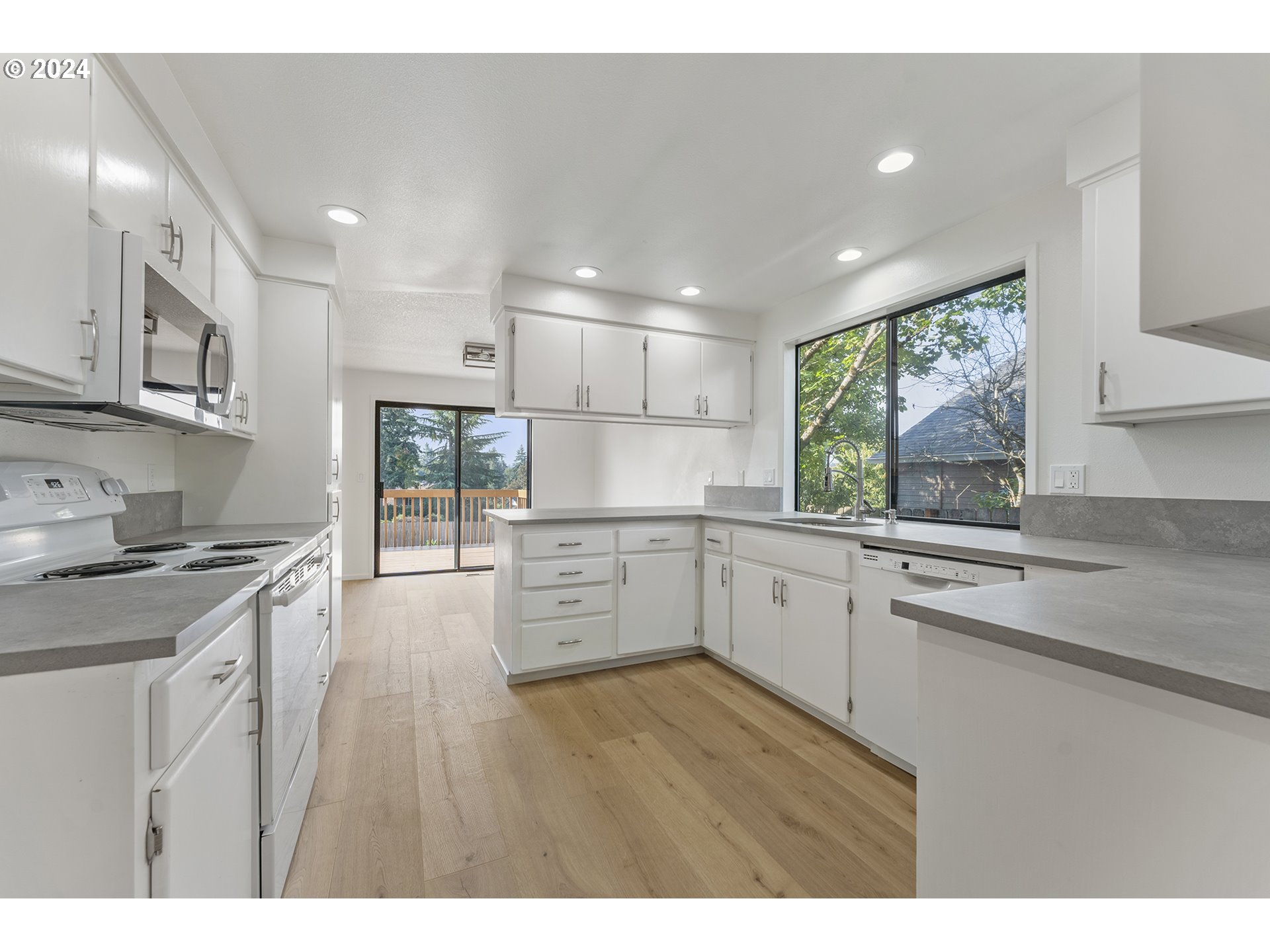 8860 Southwest Maverick Terrace Beaverton, OR 97008 - Photo 7 of 20 a kitchen with white cabinets and wooden floors