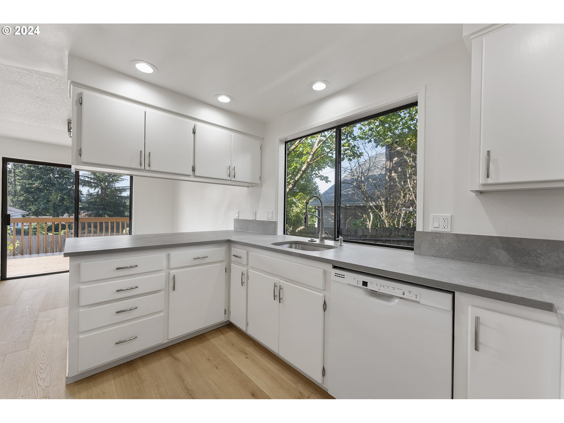 8860 Southwest Maverick Terrace Beaverton, OR 97008 - Photo 8 of 20 a kitchen with granite countertop white cabinets and a large window