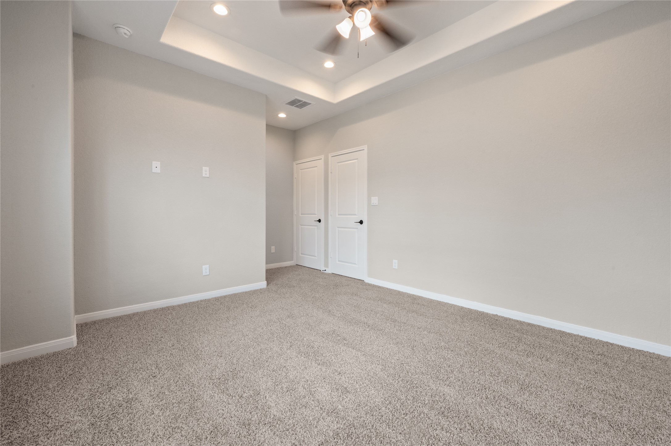 14010 Longstreet Road, Unit 2 Willis, TX 77318 - Photo 15 of 29 This room features soft carpet flooring, neutral walls, recessed lighting, and a ceiling fan. It has a clean, modern look with double doors, perfect for a cozy bedroom or office space.