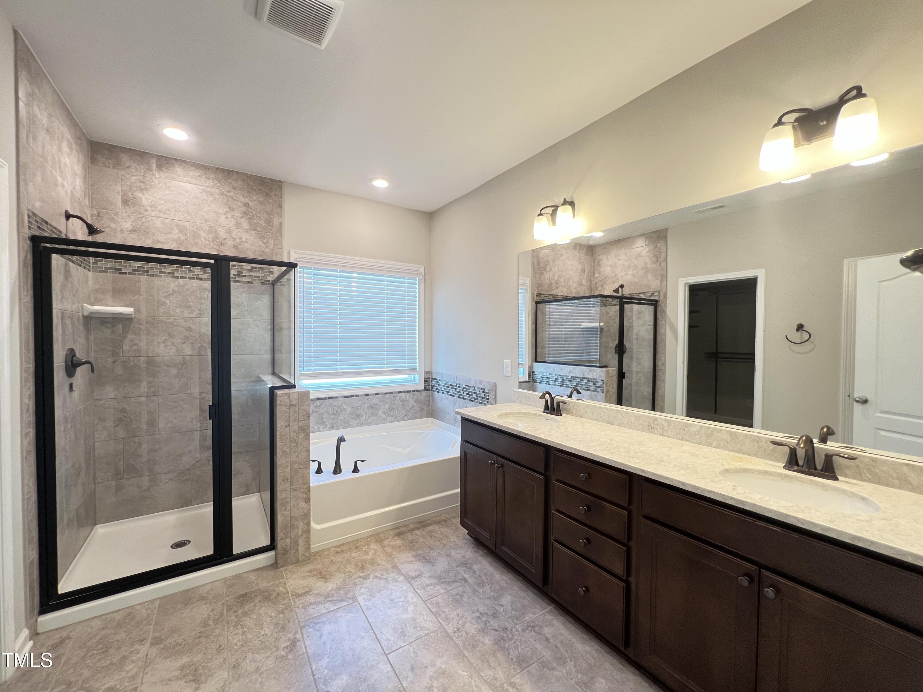 3385 Lovage Drive Apex, NC 27502 - Photo 12 of 19 a bathroom with a double vanity sink mirror and shower