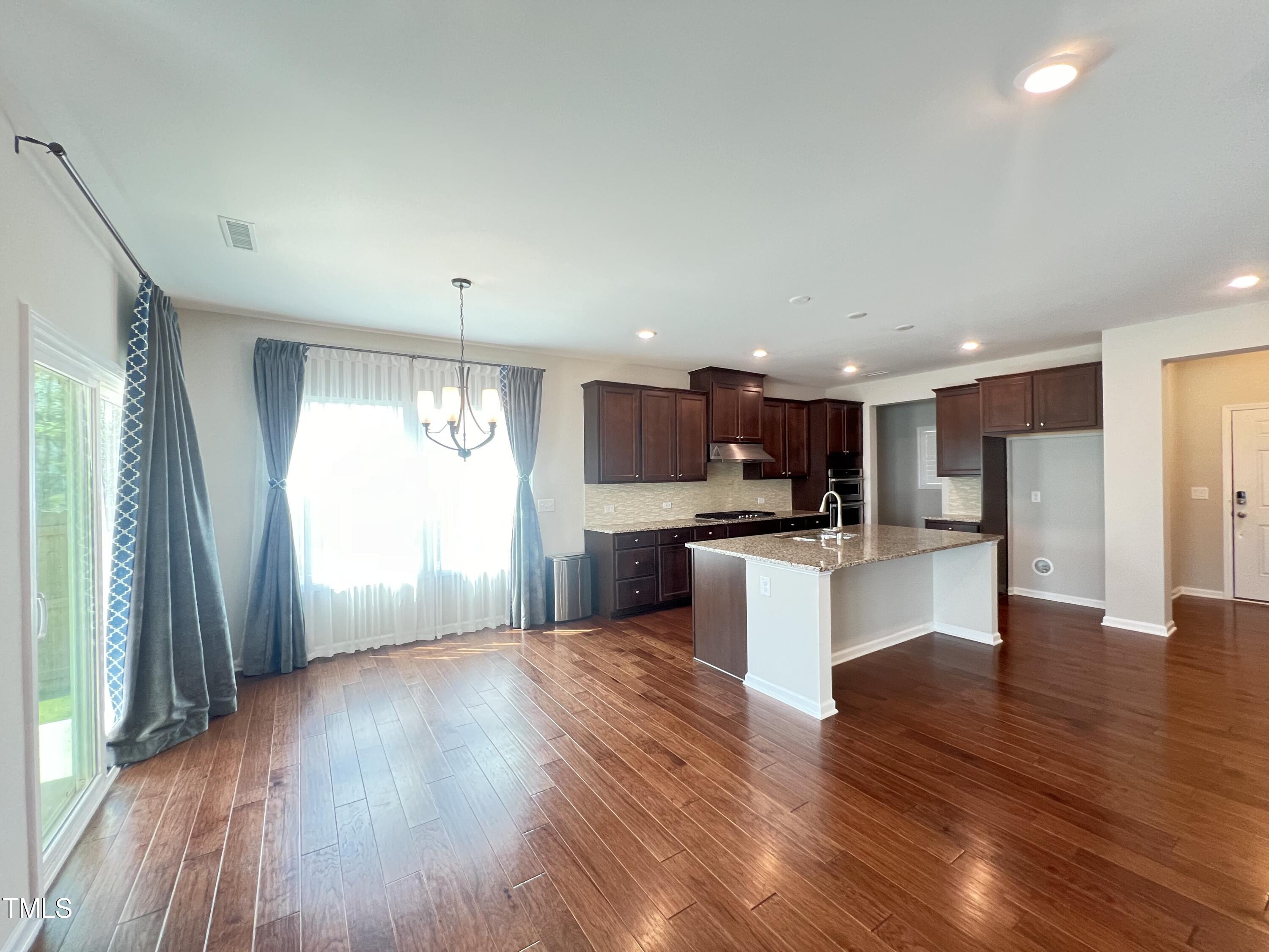 3385 Lovage Drive Apex, NC 27502 - Photo 2 of 19 a view of kitchen with kitchen island wooden floor and refrigerator