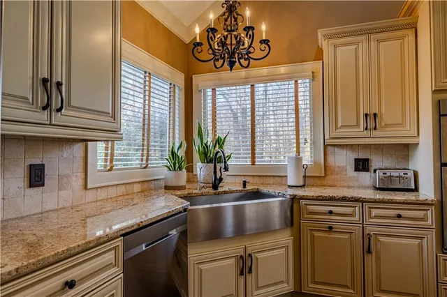 a kitchen with stainless steel appliances granite countertop a sink a stove and cabinets