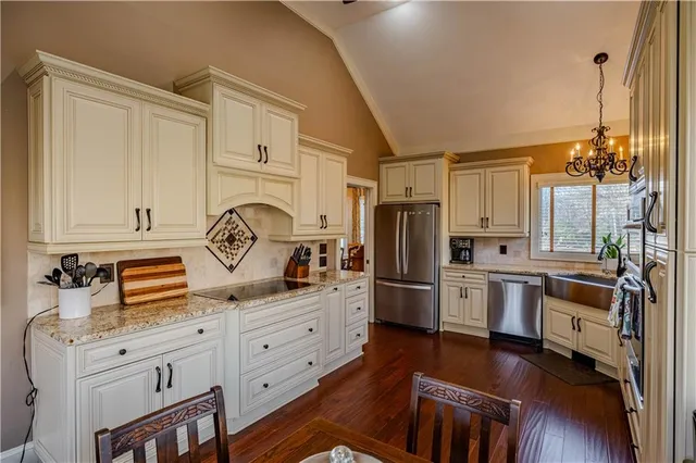 a kitchen with granite countertop a sink stove and refrigerator
