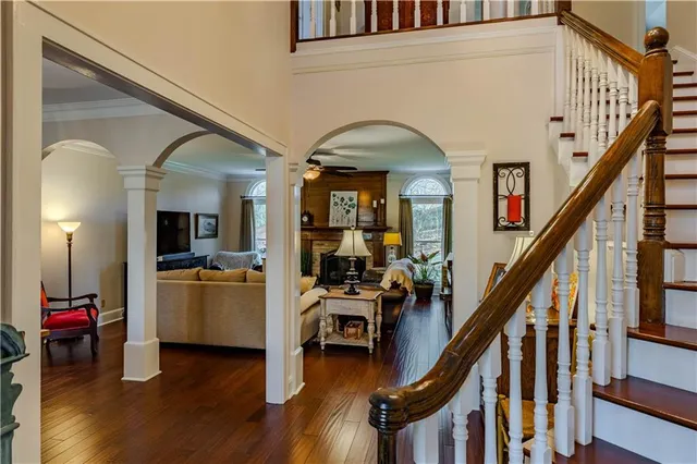 a view of a livingroom with furniture staircase and kitchen view