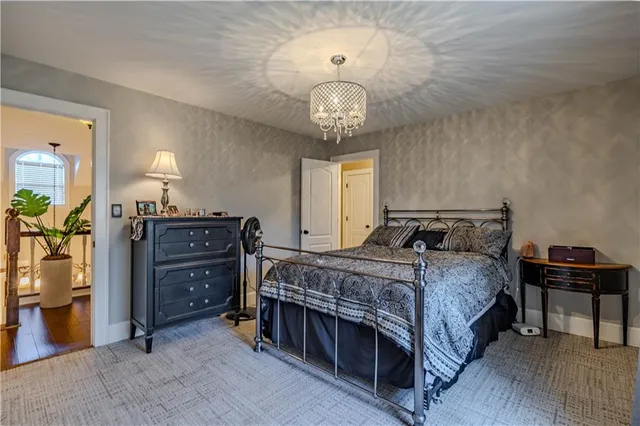 a bedroom with a bed and a chandelier