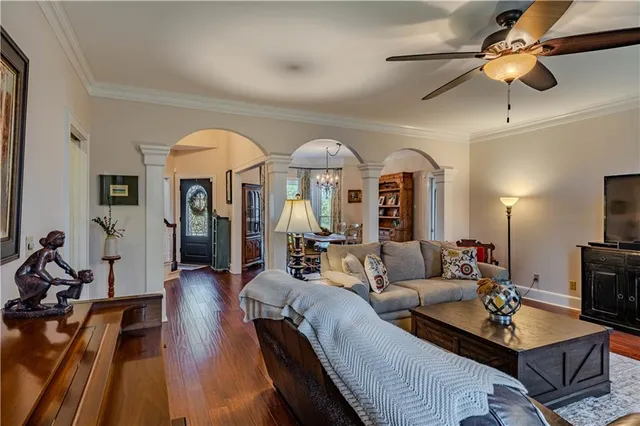 a living room with furniture a chandelier and a flat screen tv