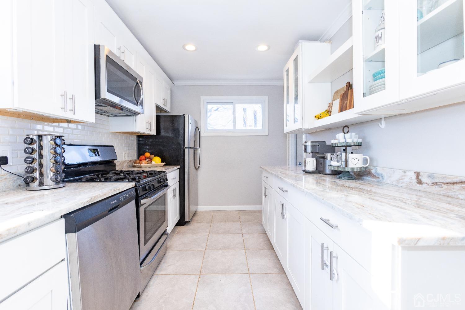 125 Tunison Road New Brunswick, NJ 08901 - Photo 13 of 24 a kitchen with stainless steel appliances granite countertop a sink stove and refrigerator