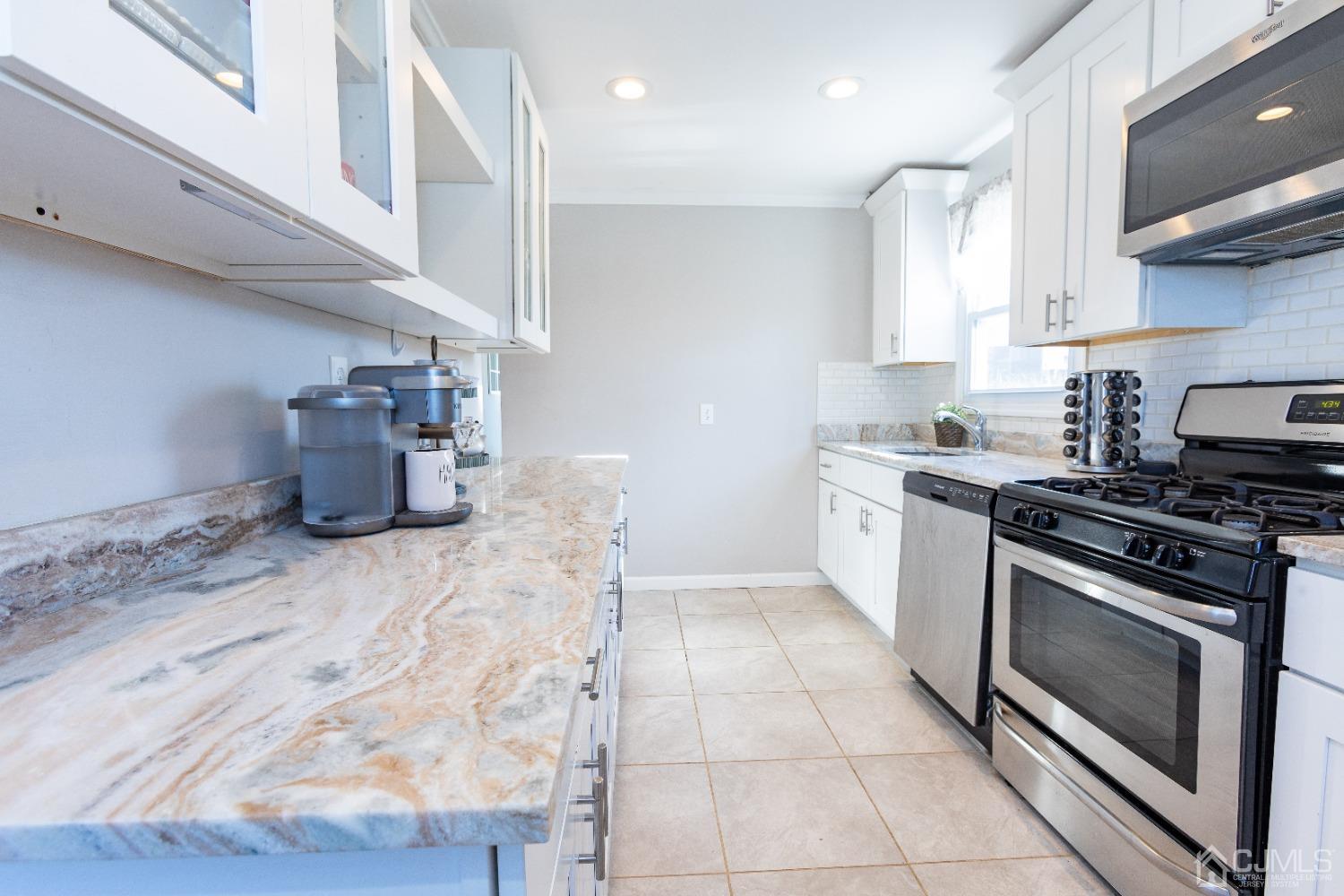 125 Tunison Road New Brunswick, NJ 08901 - Photo 14 of 24 a kitchen with a stove top oven and cabinets