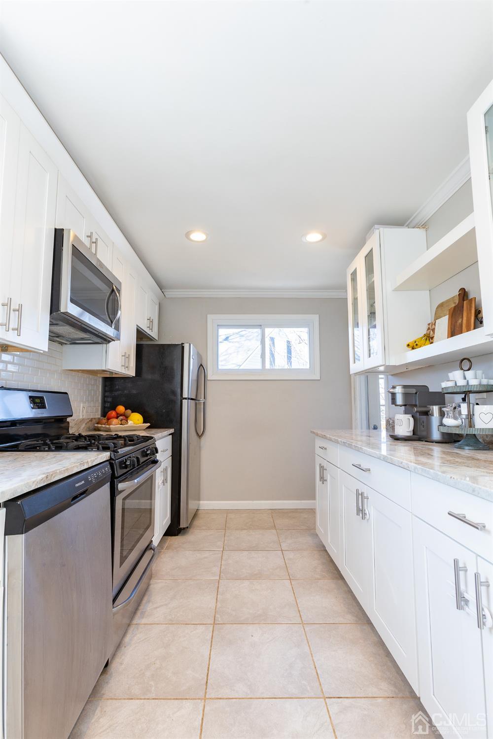 125 Tunison Road New Brunswick, NJ 08901 - Photo 22 of 24 a kitchen with stainless steel appliances granite countertop a sink and dishwasher a stove top oven with wooden floor