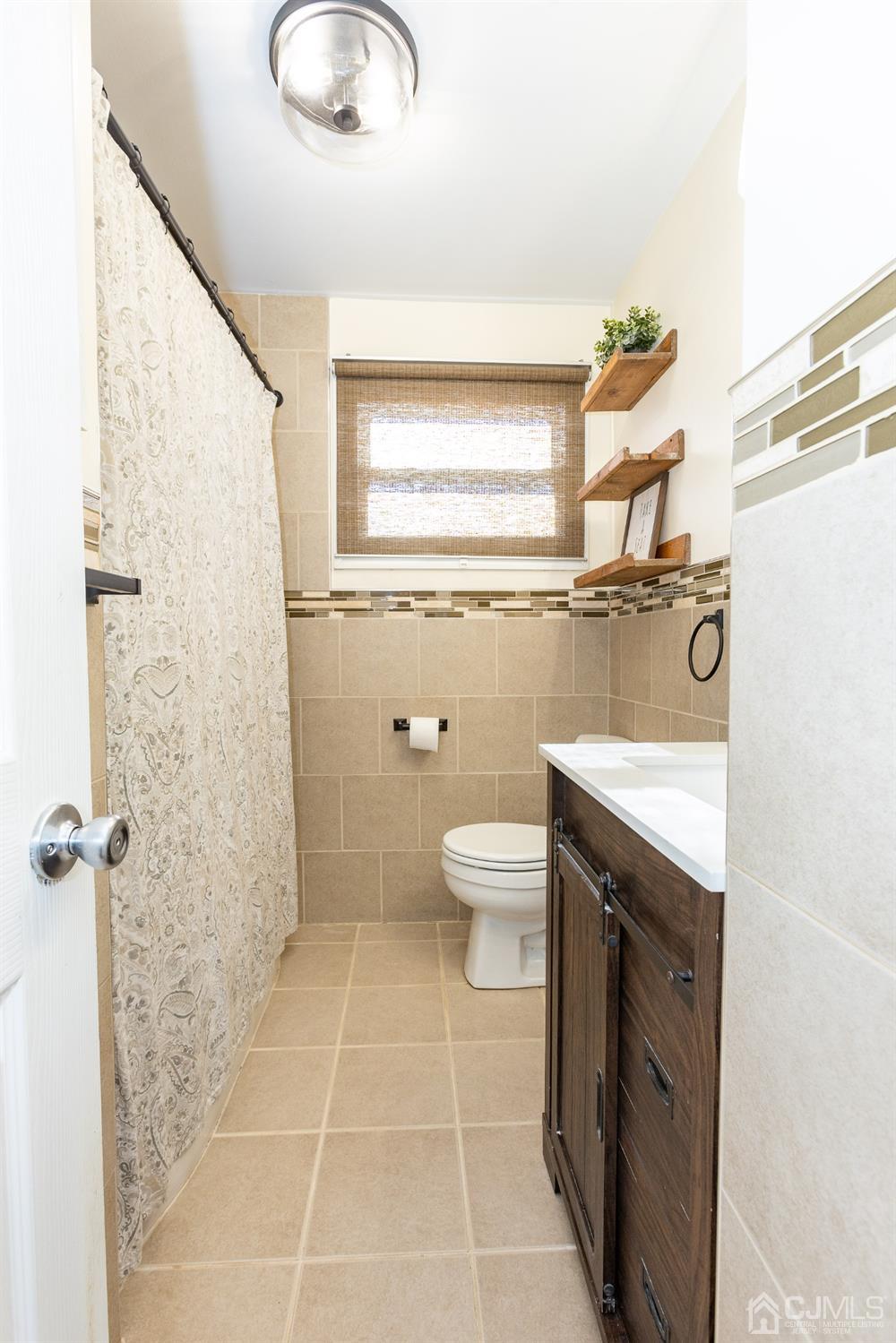 125 Tunison Road New Brunswick, NJ 08901 - Photo 9 of 24 a bathroom with a granite countertop sink a toilet and a mirror