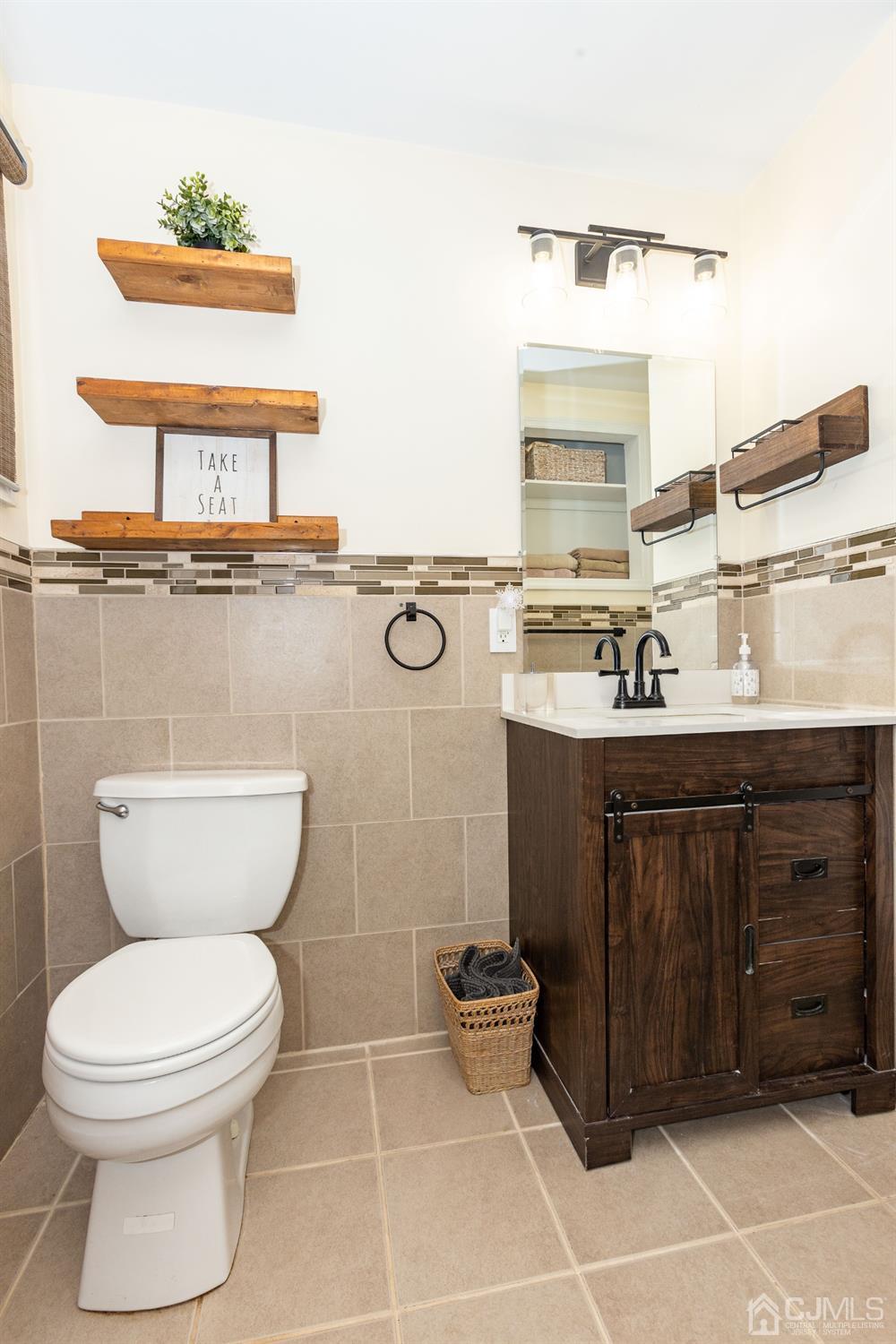 125 Tunison Road New Brunswick, NJ 08901 - Photo 10 of 24 a bathroom with a toilet a sink and mirror