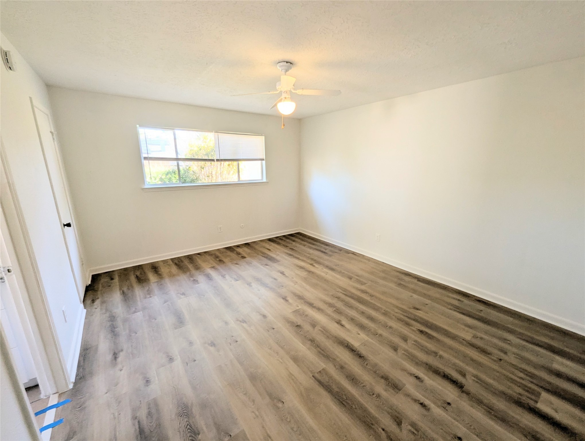 17602 Crestline Road Humble, TX 77396 - Photo 18 of 25 an empty room with wooden floor cabinet and windows
