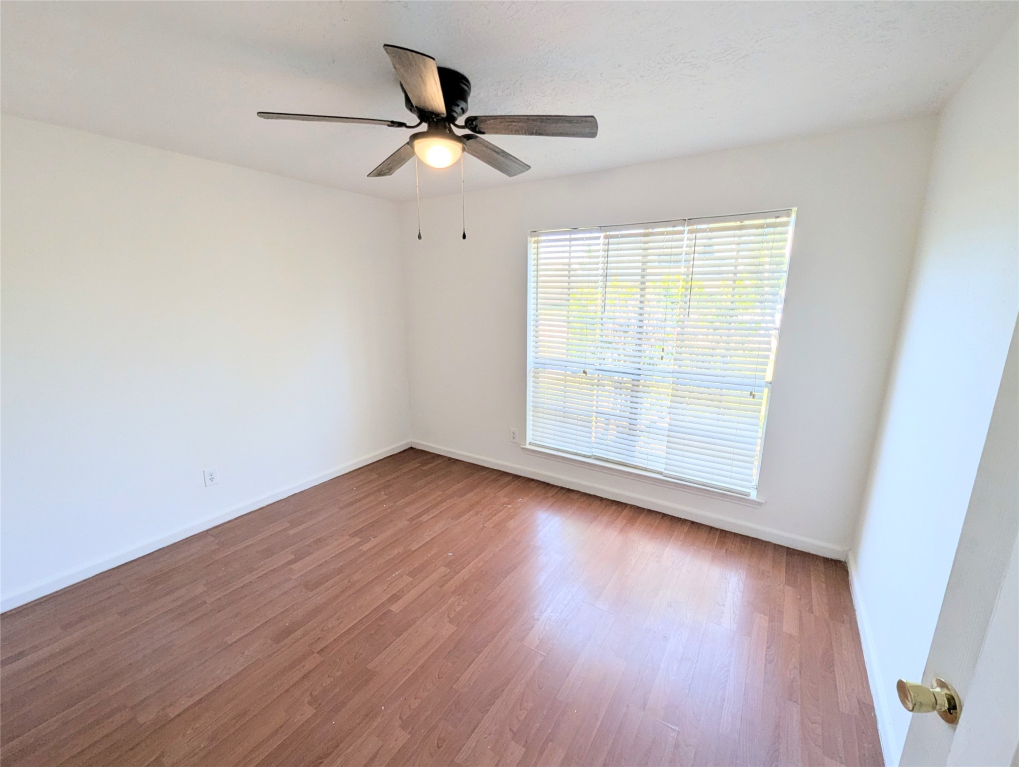 17602 Crestline Road Humble, TX 77396 - Photo 10 of 25 an empty room with wooden floor fan and windows