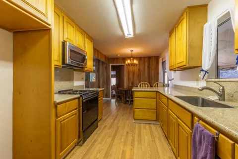 a kitchen with a sink a counter top space stainless steel appliances and a window