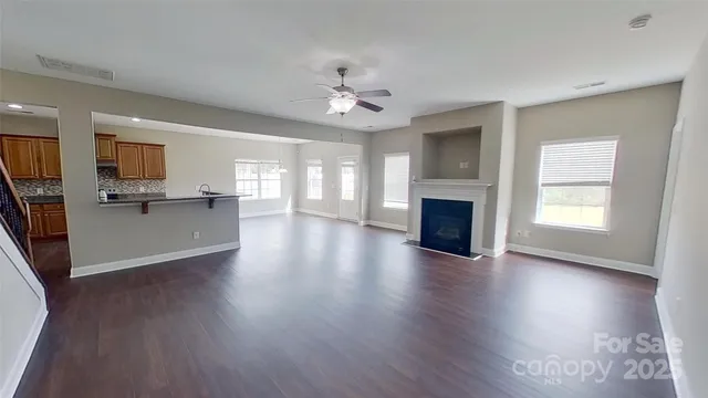 wooden floor fireplace and windows in an empty room