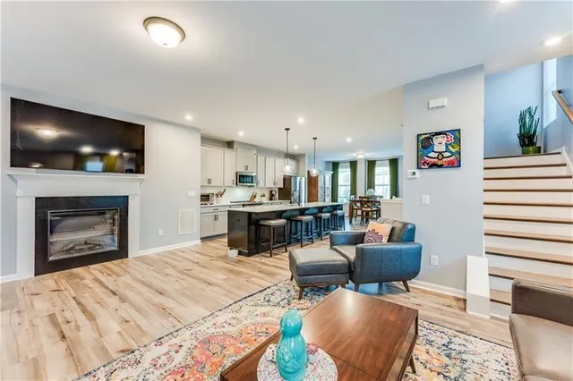 a living room with furniture a flat screen tv and kitchen view