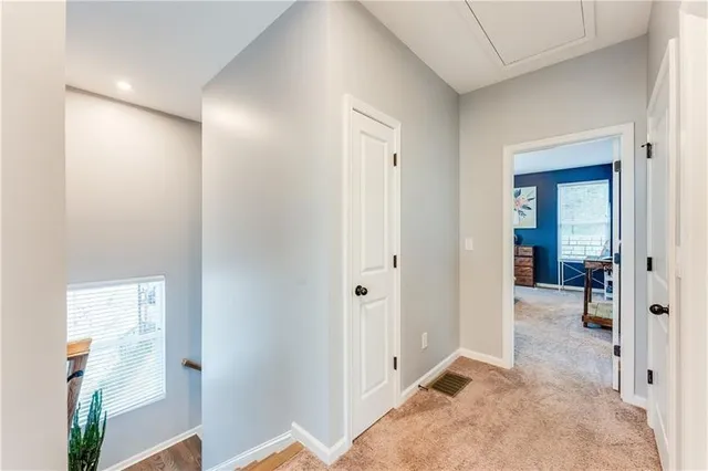 a view of a hallway with a livingroom and a bathroom with a sink