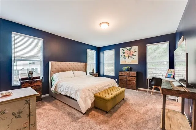 a bedroom with a large bed and large windows