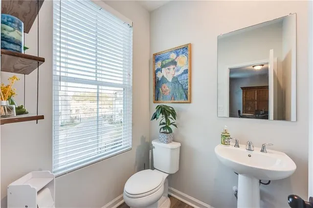 a bathroom with a toilet a sink and a large mirror