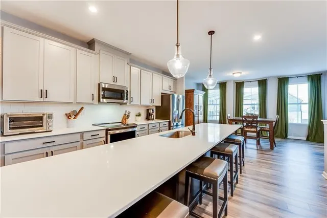 a kitchen with stainless steel appliances kitchen island granite countertop a stove a sink a microwave a center island and cabinets