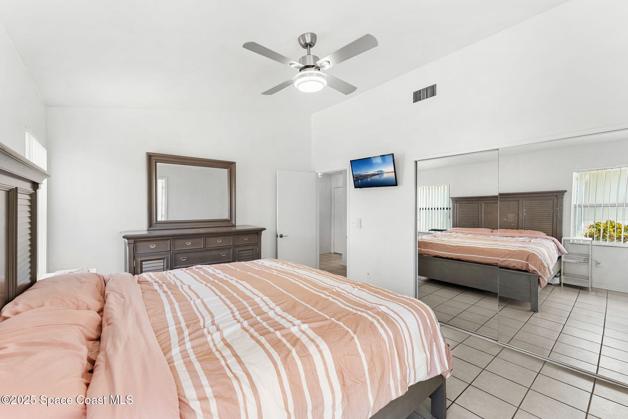 1157 Goldenrod Circle Northeast Palm Bay, FL 32905 - Photo 14 of 31 a bedroom with a large bed and a chandelier
