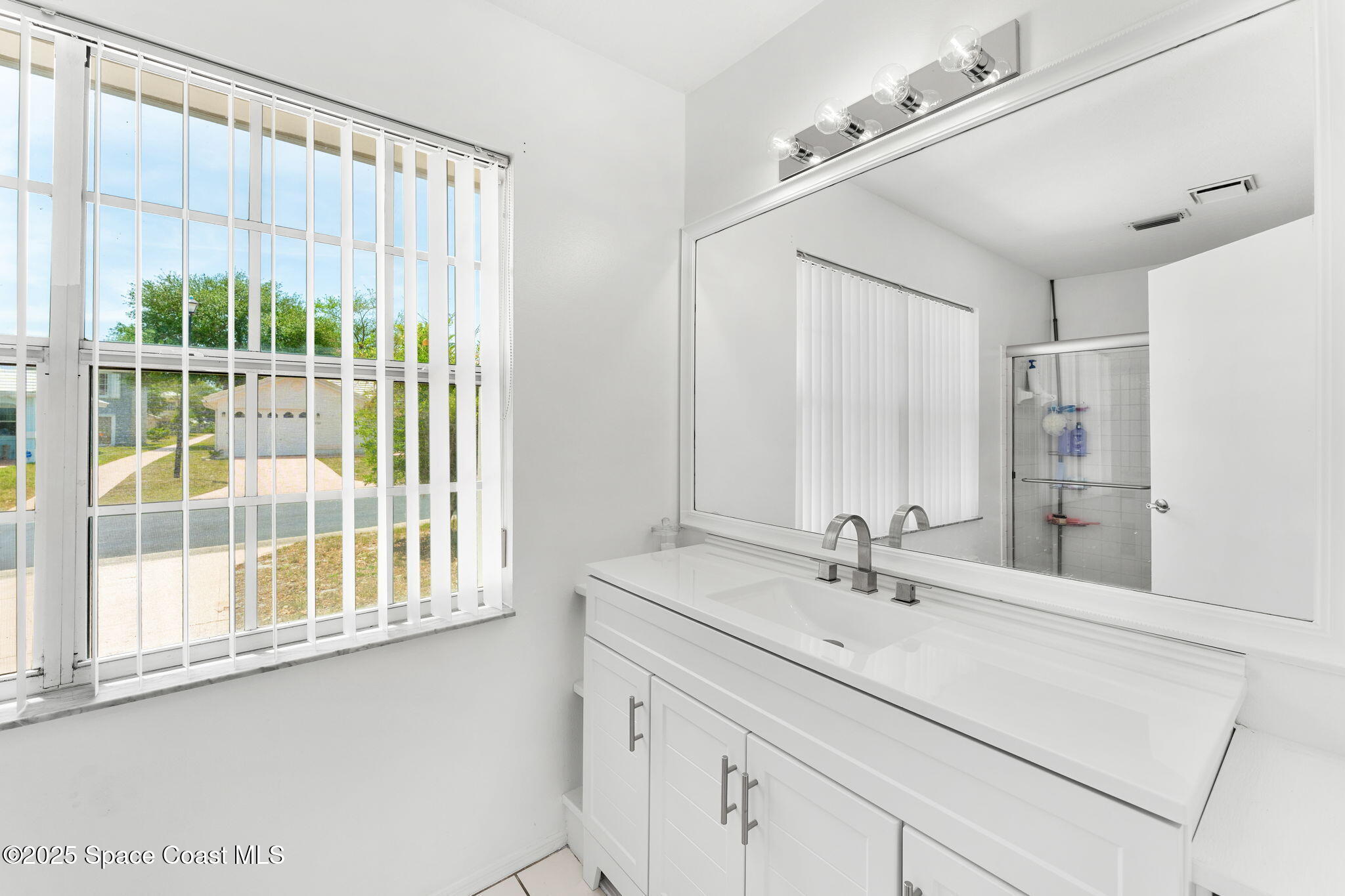 1157 Goldenrod Circle Northeast Palm Bay, FL 32905 - Photo 17 of 31 a bathroom with a sink and a mirror