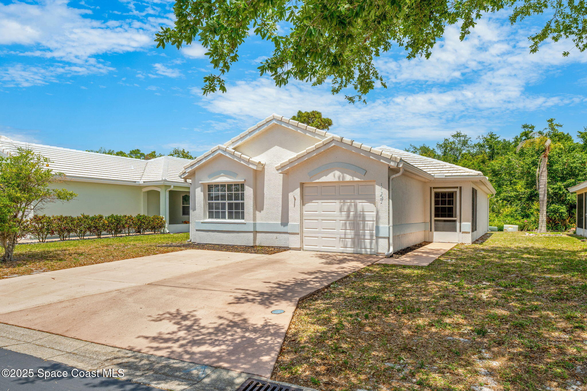1157 Goldenrod Circle Northeast Palm Bay, FL 32905 - Photo 27 of 31 a front view of a house with a garden