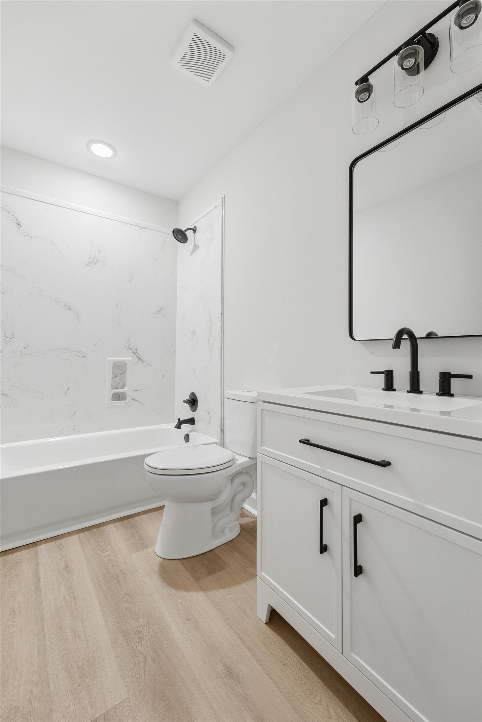 4683 Belmont Road Hernando, MS 38632 - Photo 20 of 21 Modern bathroom featuring a white vanity with black hardware, an integrated sink, and a black-framed rectangular mirror