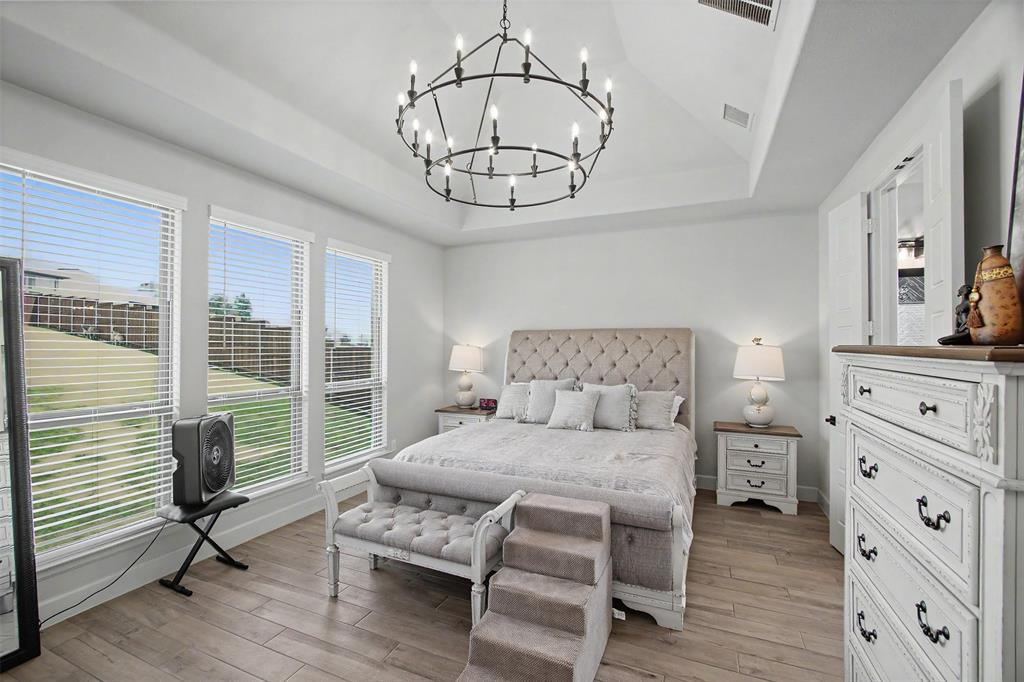 116 Derrett Lane Rhome, TX 76078 - Photo 11 of 30 a bedroom with a bed and a chandelier