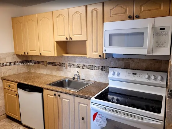 a kitchen with granite countertop a sink and a stove top oven