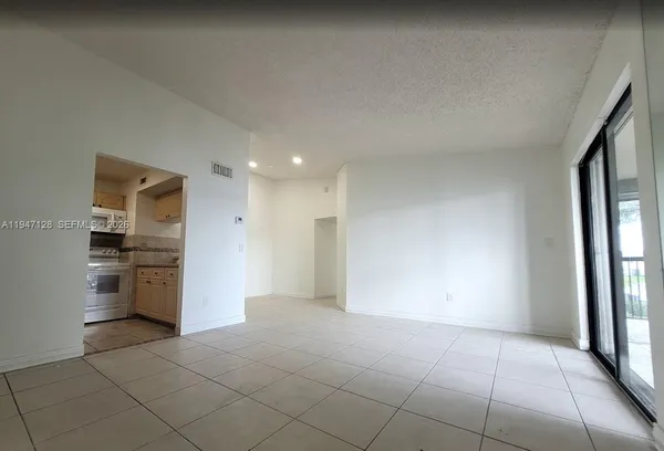 a view of a kitchen with a sink refrigerator and cabinets