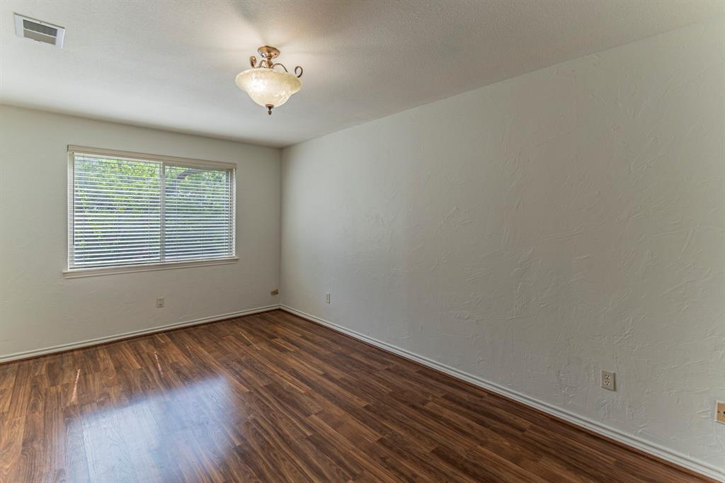 127 Nicklaus Nook Lancaster, TX 75146 - Photo 18 of 37 Empty room featuring a textured wall and dark wood finished floors